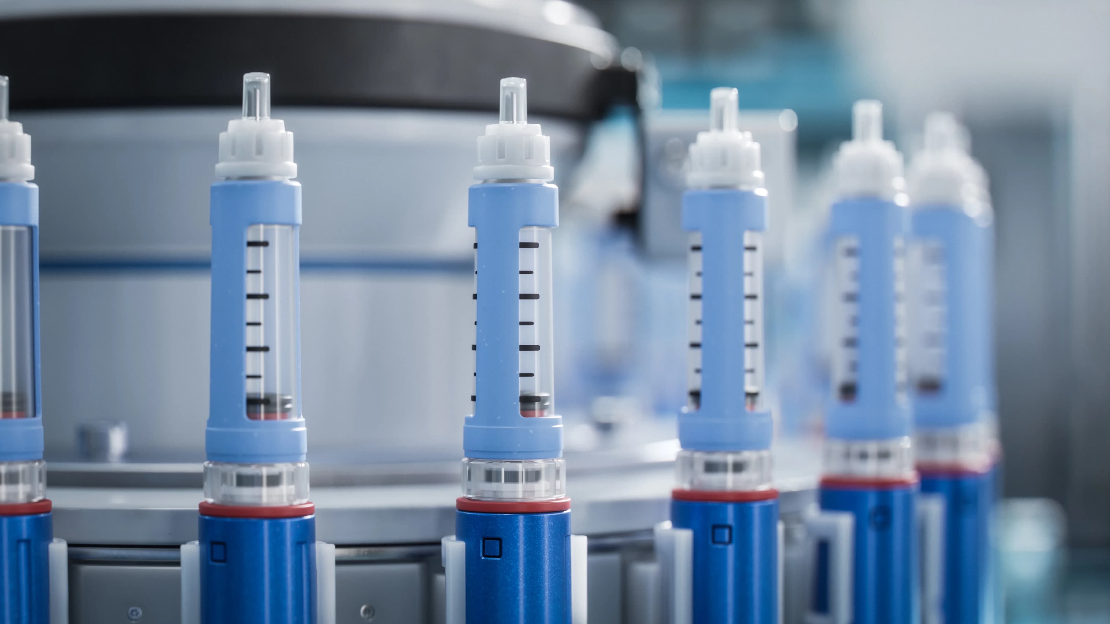 Rows of medication pens used for employer coverage and benefits economics.